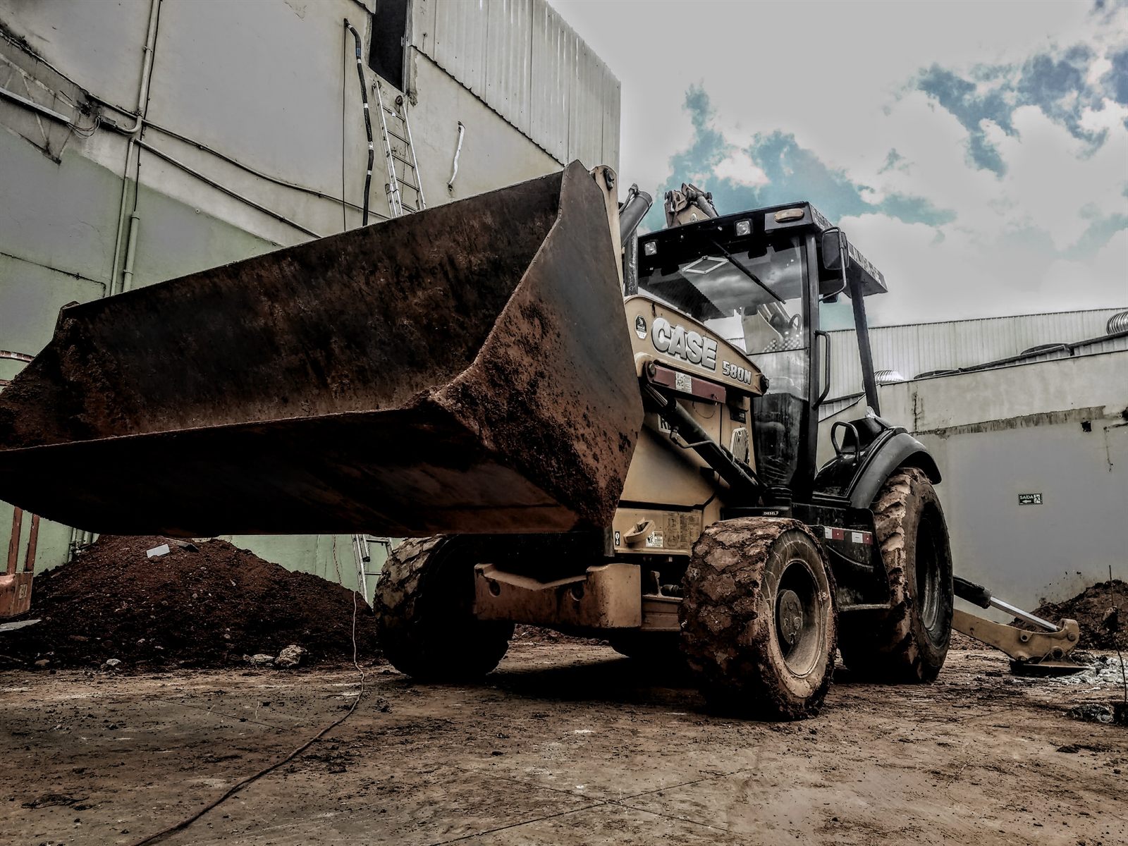 Retroescavadeira executando escavação lateral em obra