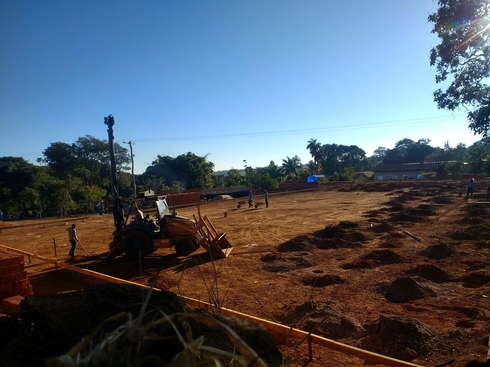 Retroescavadeira em terreno com terraplanagem em andamento